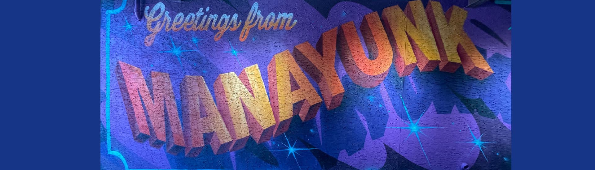 Colorful mural reading "Greetings from MANAYUNK."